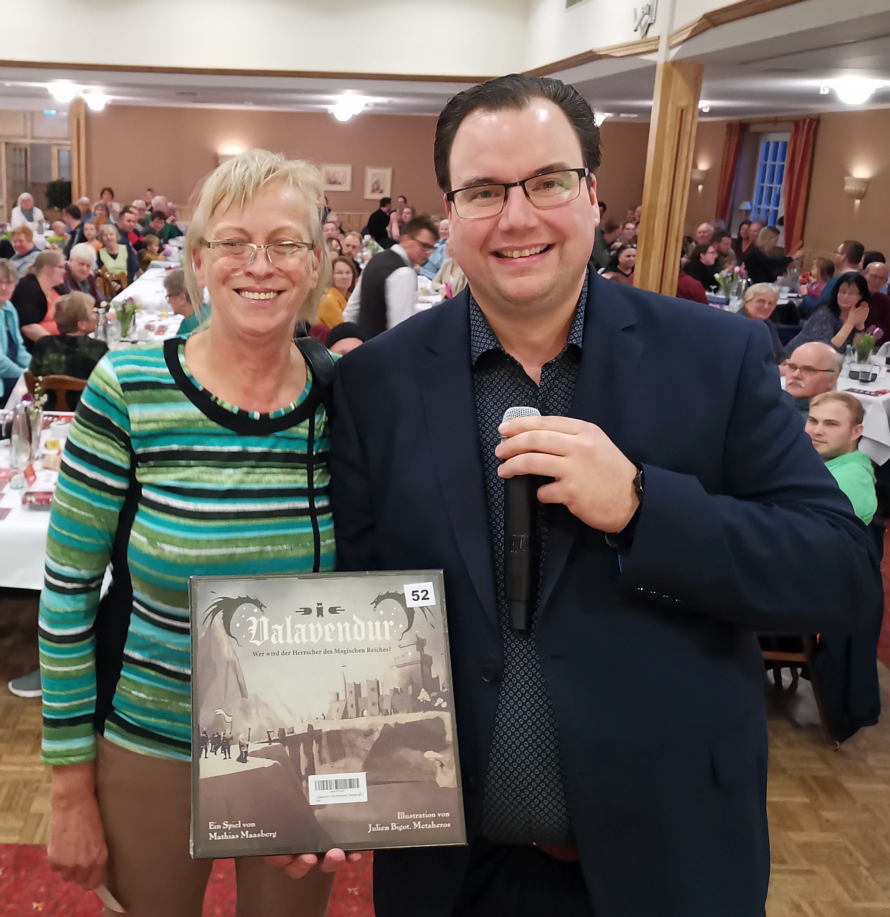 Ein in Wardenburg entwickleltes Spiel hat diese Gewinnerin gewonnen und hier von Bühnenheld Martin Bliefernich bei der Auslosungsshow der 30. Wardenburger Tombola überreicht bekommen. Foto Uta Grundmann-Abonyi Wirtschaftsförderung Wardenburg  www.agentur-grabo.de