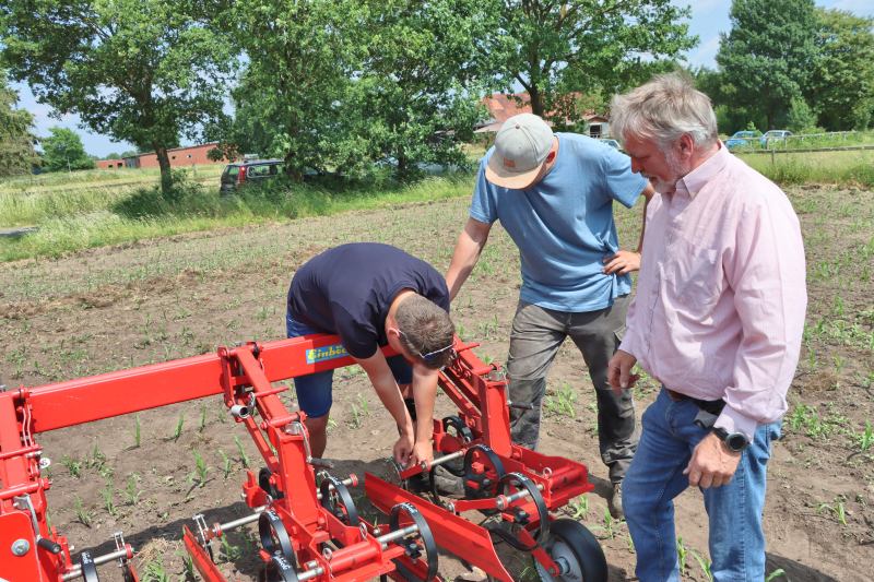 Kenntnisse in der Praxis anwenden: Die Berufsschüler dürfen mit Hilfe von Biohof-Pächter Gustav Wolters die Hacke-Maschine einstellen. Foto: Carlo Dierßen OOWV