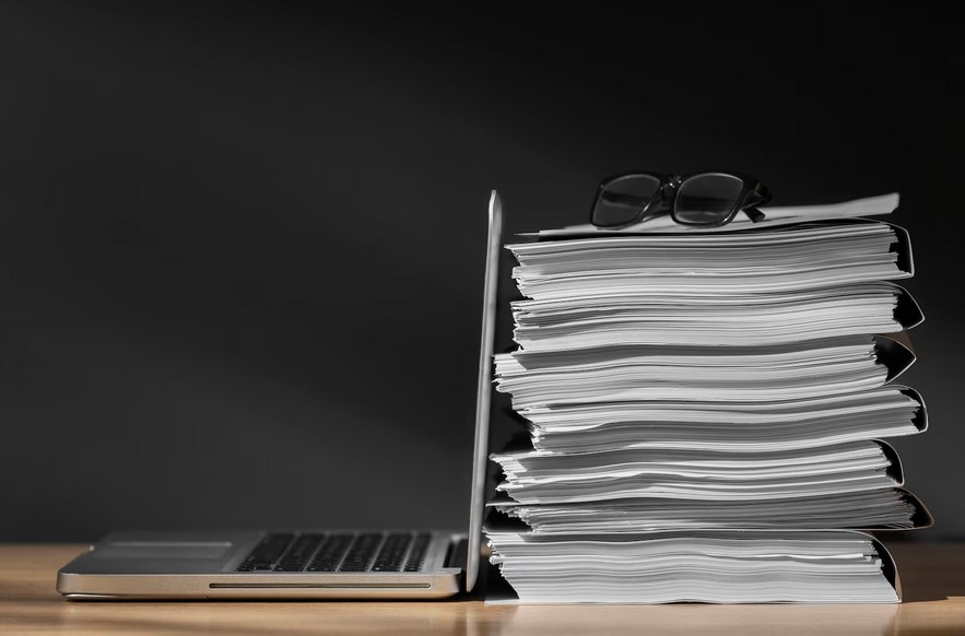 Entlastung von Routinearbeiten im Büro. Foto: Magnific https://www.magnific.com/free-photo/still-life-documents-stack_95018681.htm bürokratie_im_mittelstand_free-photo_still-life-documents-stack_95018681