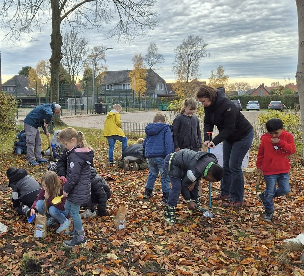 Schüler der Grundschule Wardenburg pflanzten Blumenzwiebeln auf dem Gelände an der Litteler Straße in Wardenburg ein. Konrektorin und Klassenlehrerin Hile Büscher und Maria Penning unterstützten die Kinder dabei. Foto: Maria Penning www.landkreis-kurier.de